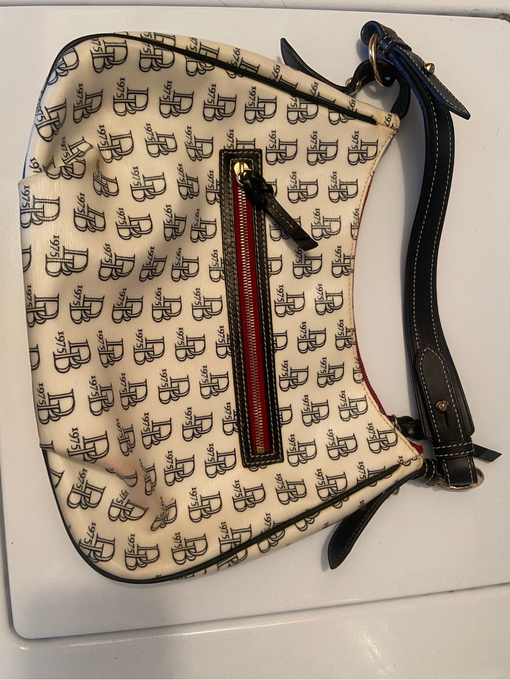 Dooney & Bourke Cream Shoulder Bag with Black Trim and Red Accent